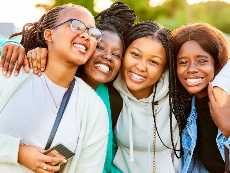 A group photo of four Black girls smiling. 