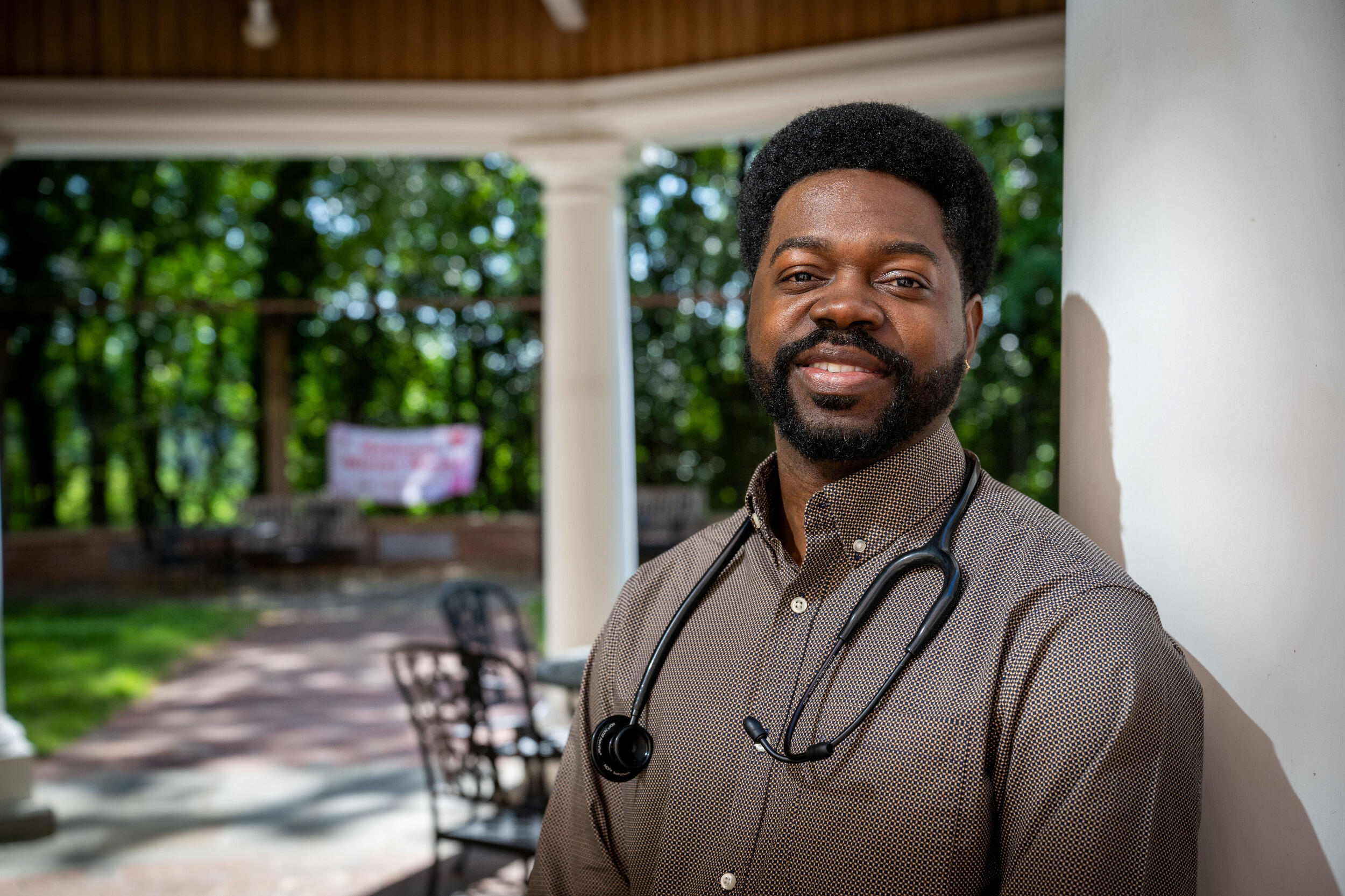 A man wearing a collared shirt and a stethoscope around his neck.
