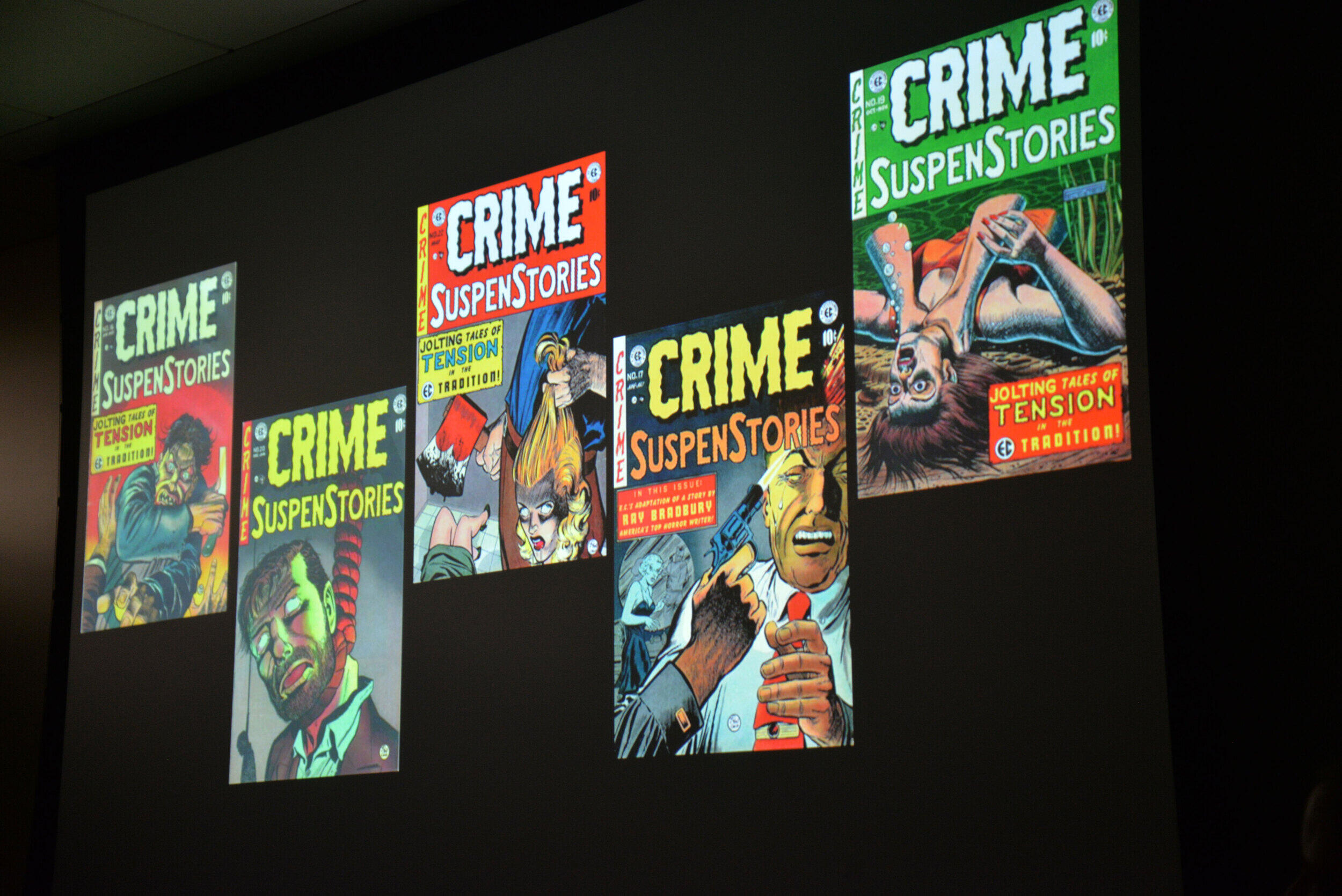 Four covers of editions of Crime SuspenStories are displayed on a screen during a presentation.