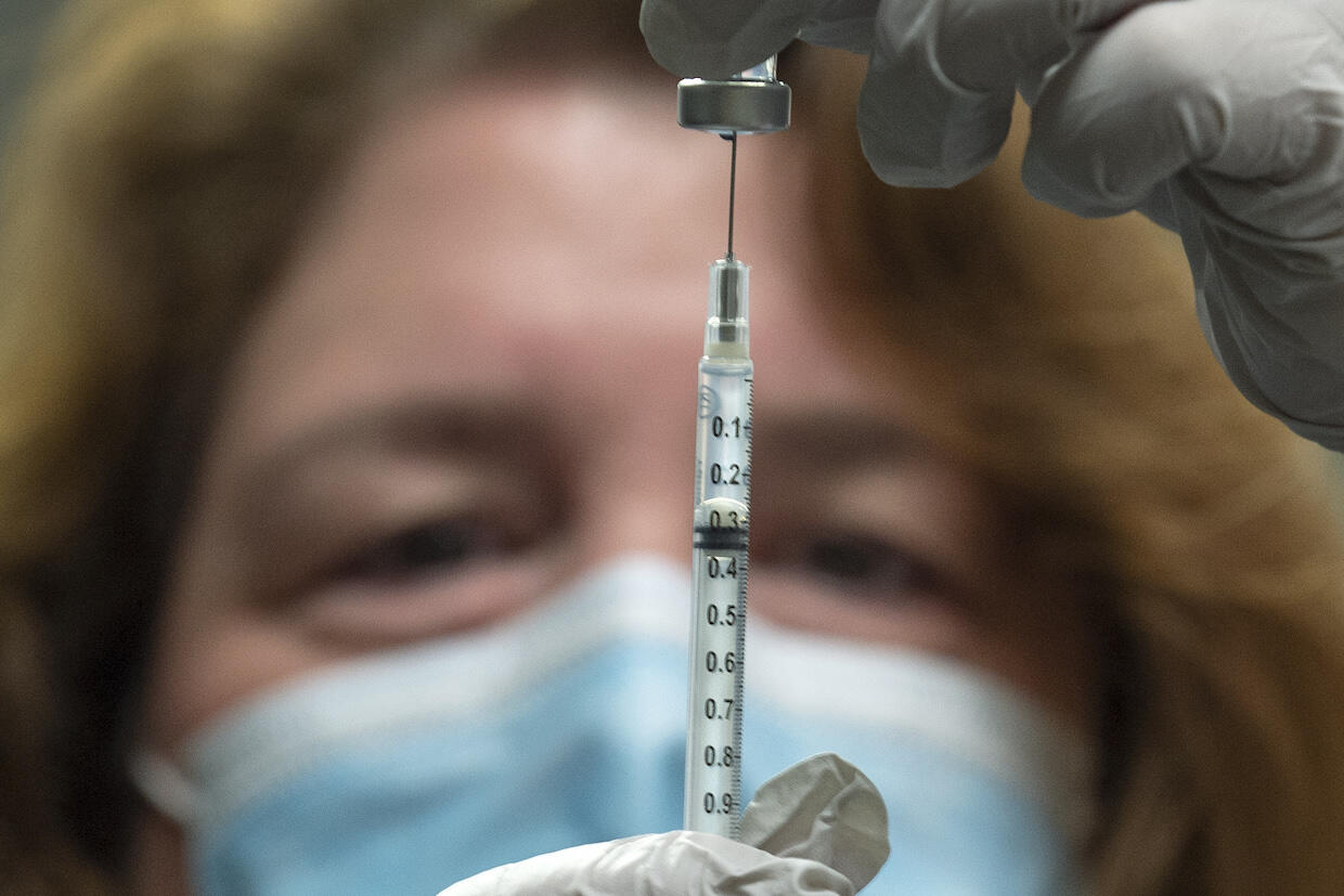 VCU Health pharmacy manager Rebeccah Collins fills a syringe with Pfizer’s COVID-19 vaccine.