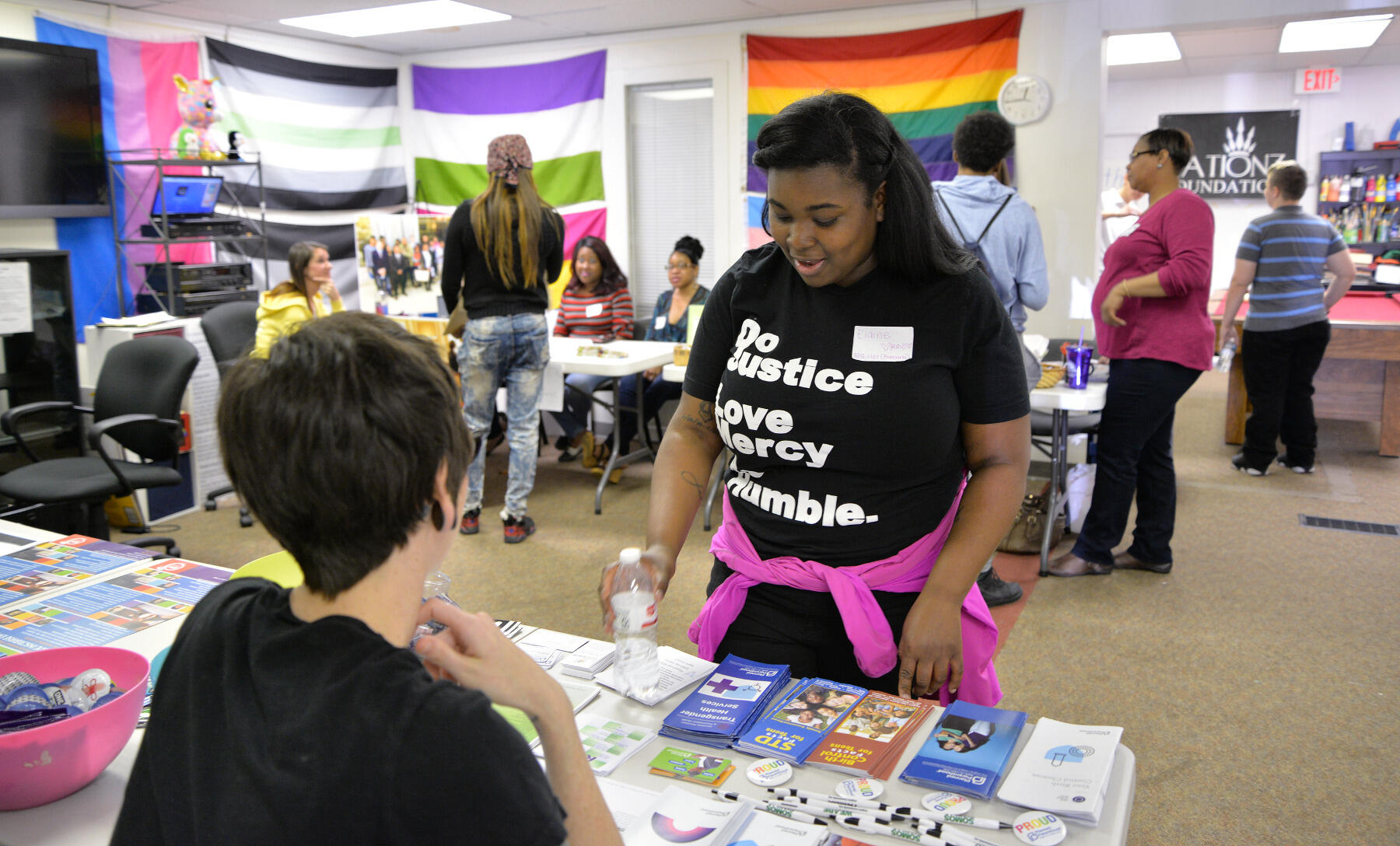 Elaine Williams, a senior social work major at VCU and a member of Advocates for Richmond Youth, talks with representatives of Richmond-area nonprofits and service providers at the pop-up drop-in center at Side By Side.