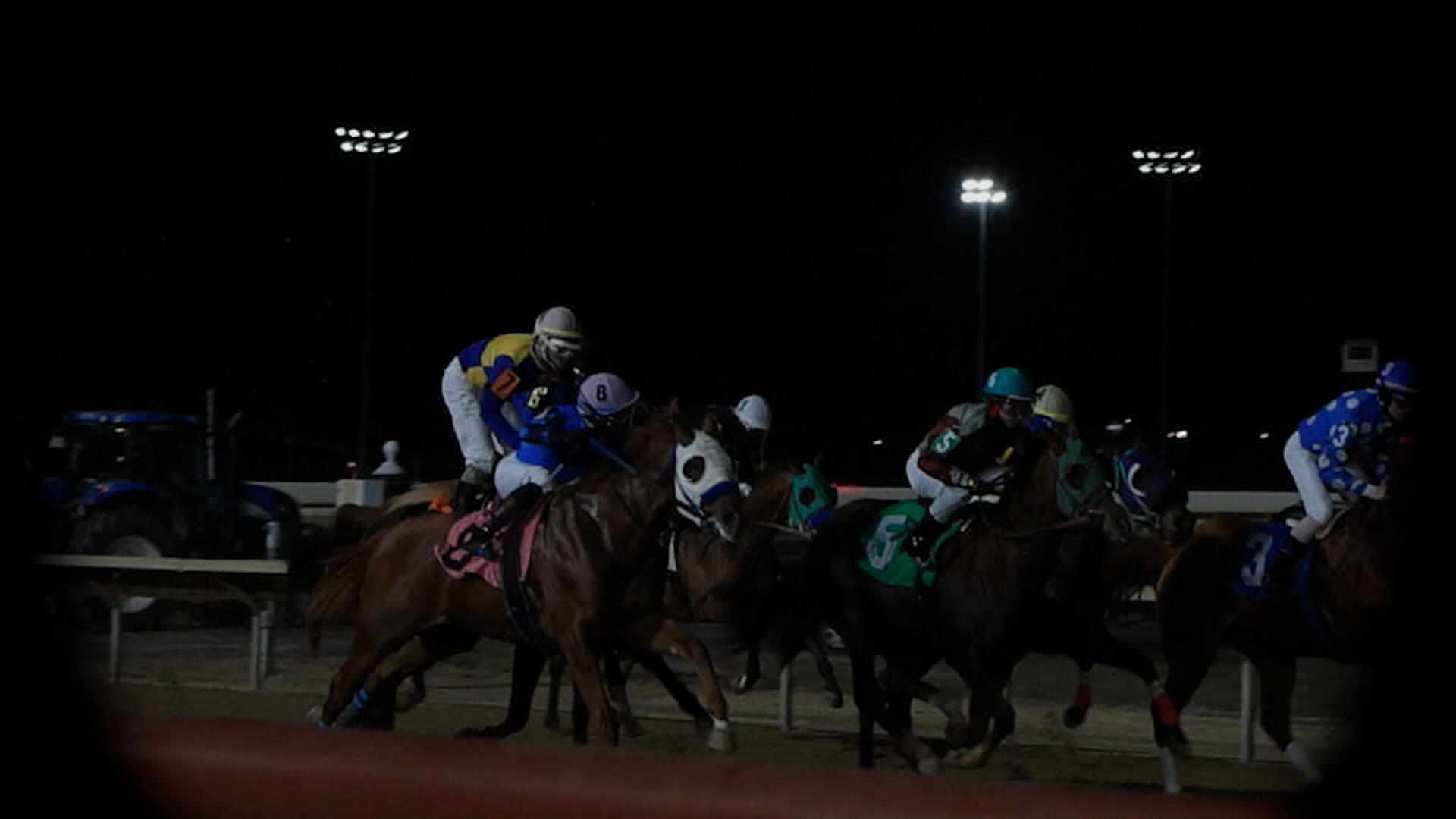 A photo that shows horse jockeys riding horses. 