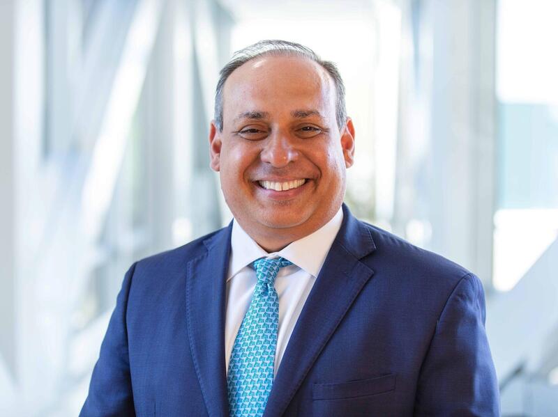 A smiling man in a coat and tie.