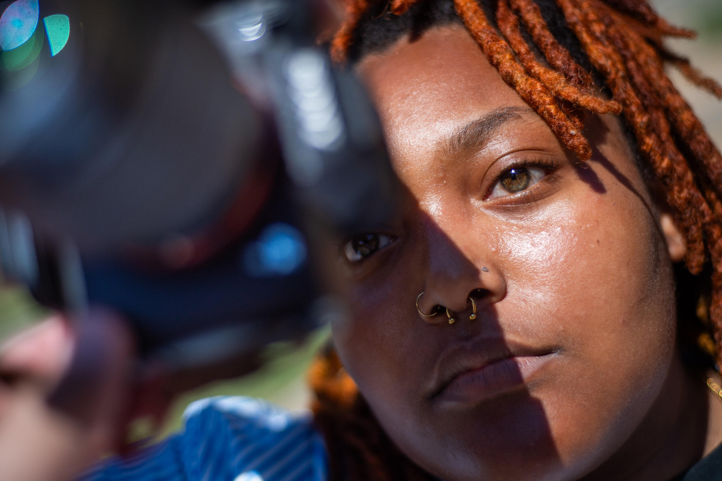 A photo of a woman holding a camera up to her face. 