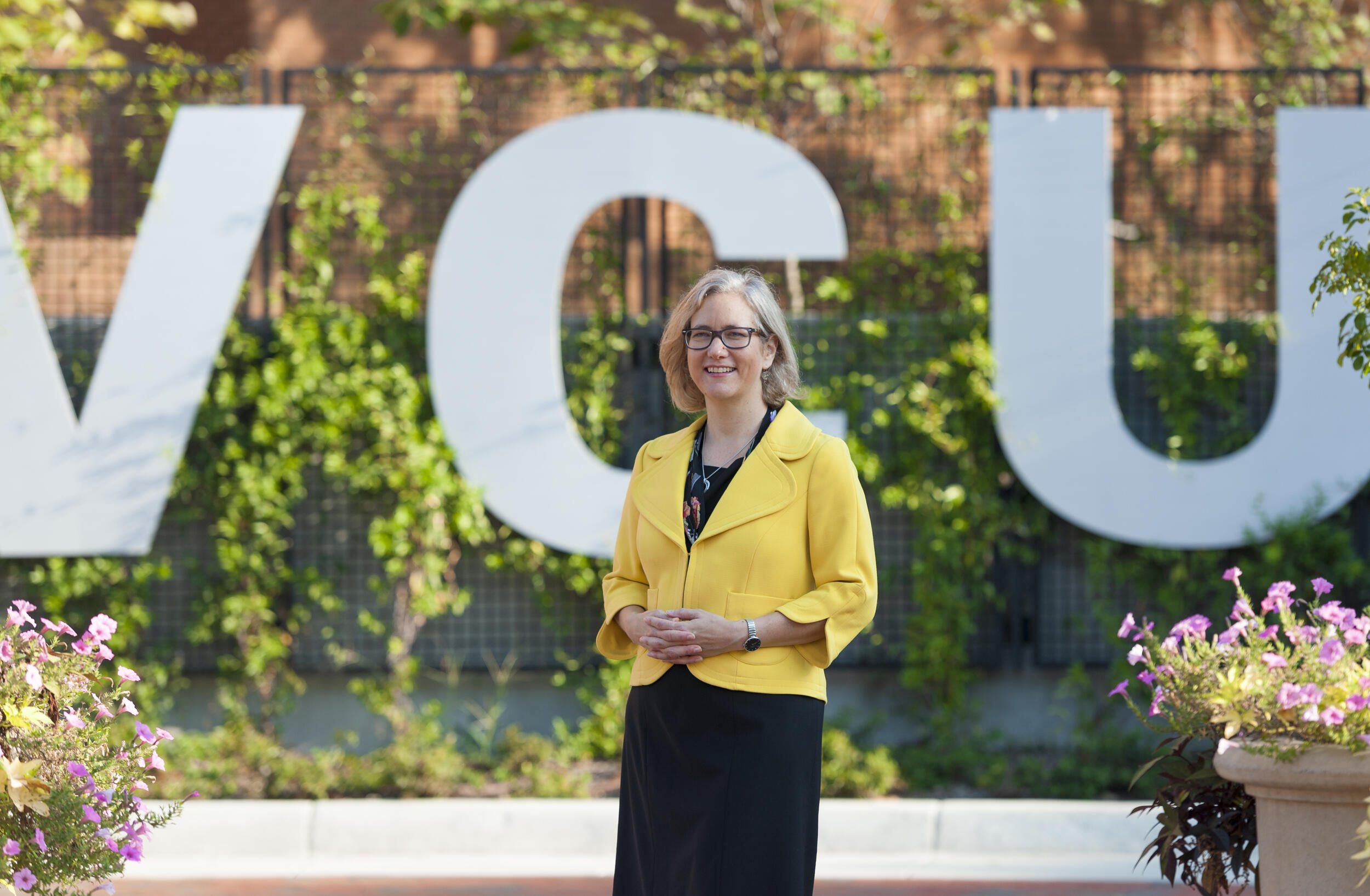 Beth Angell, Ph.D. standing in front of a \"VCU\" letter sign 