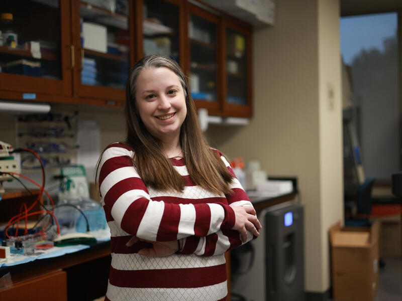 A photo of a woman standing in a lab. 