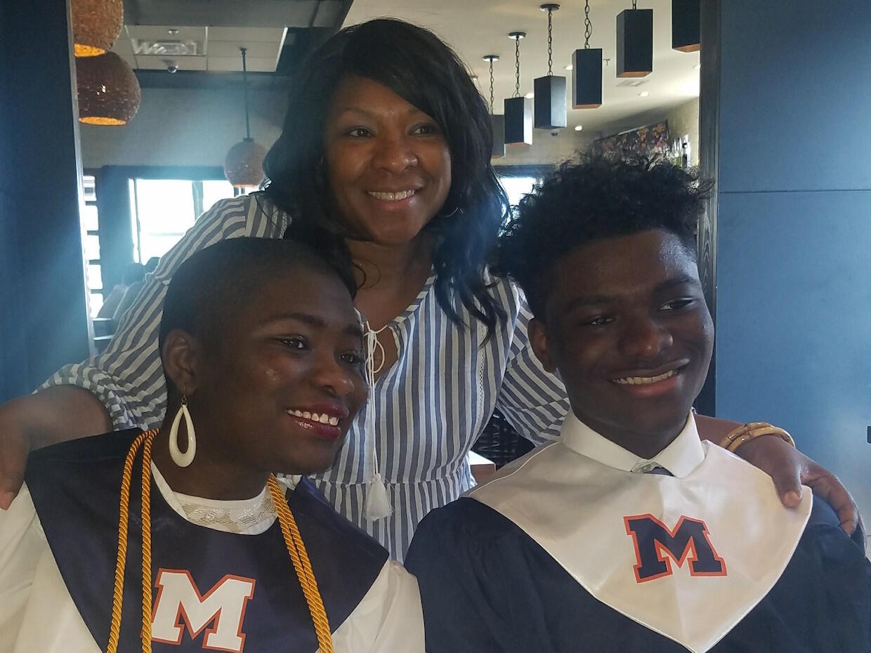 Mother and twin children at their graduation from high school