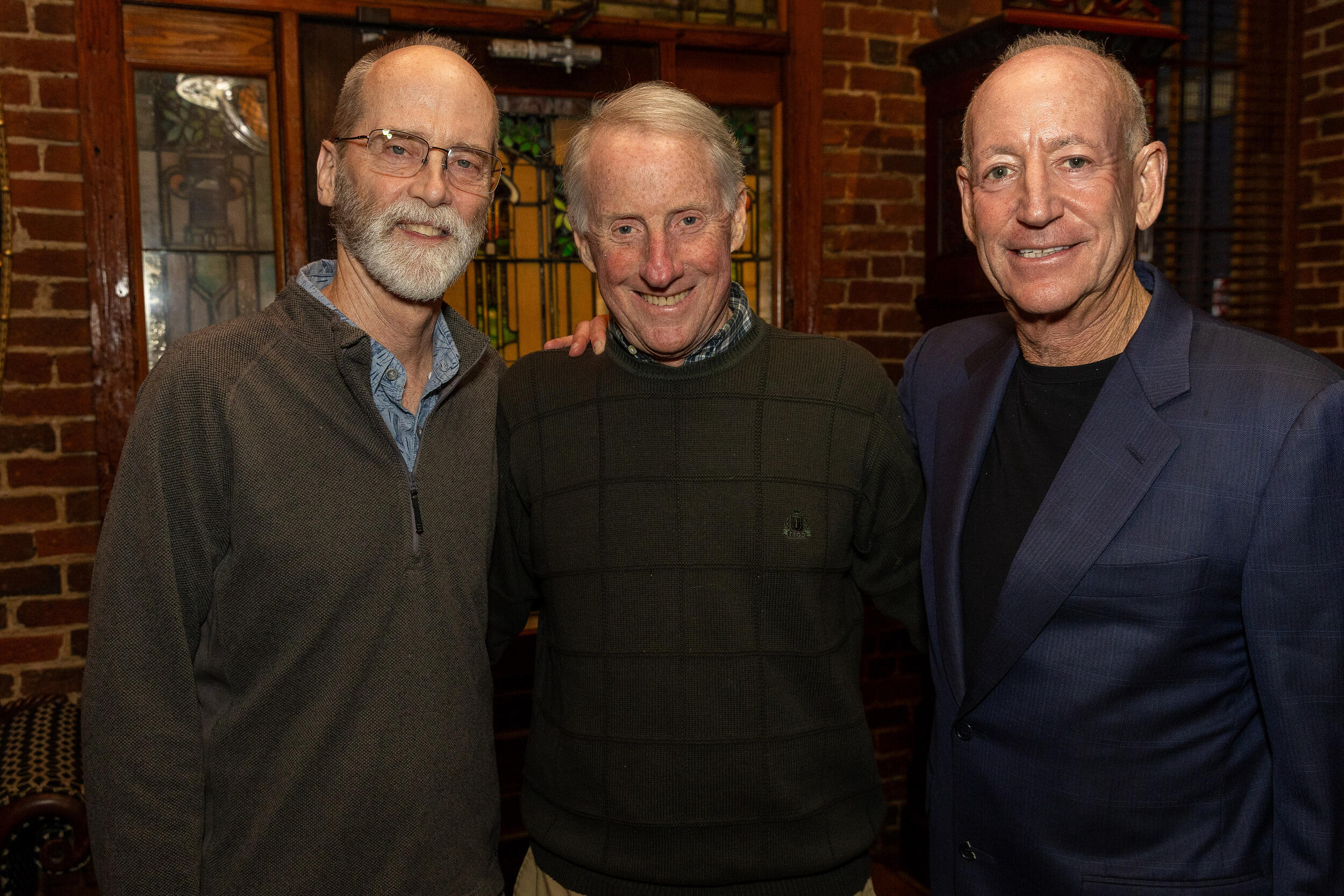 A photo of three men from the waist up. 