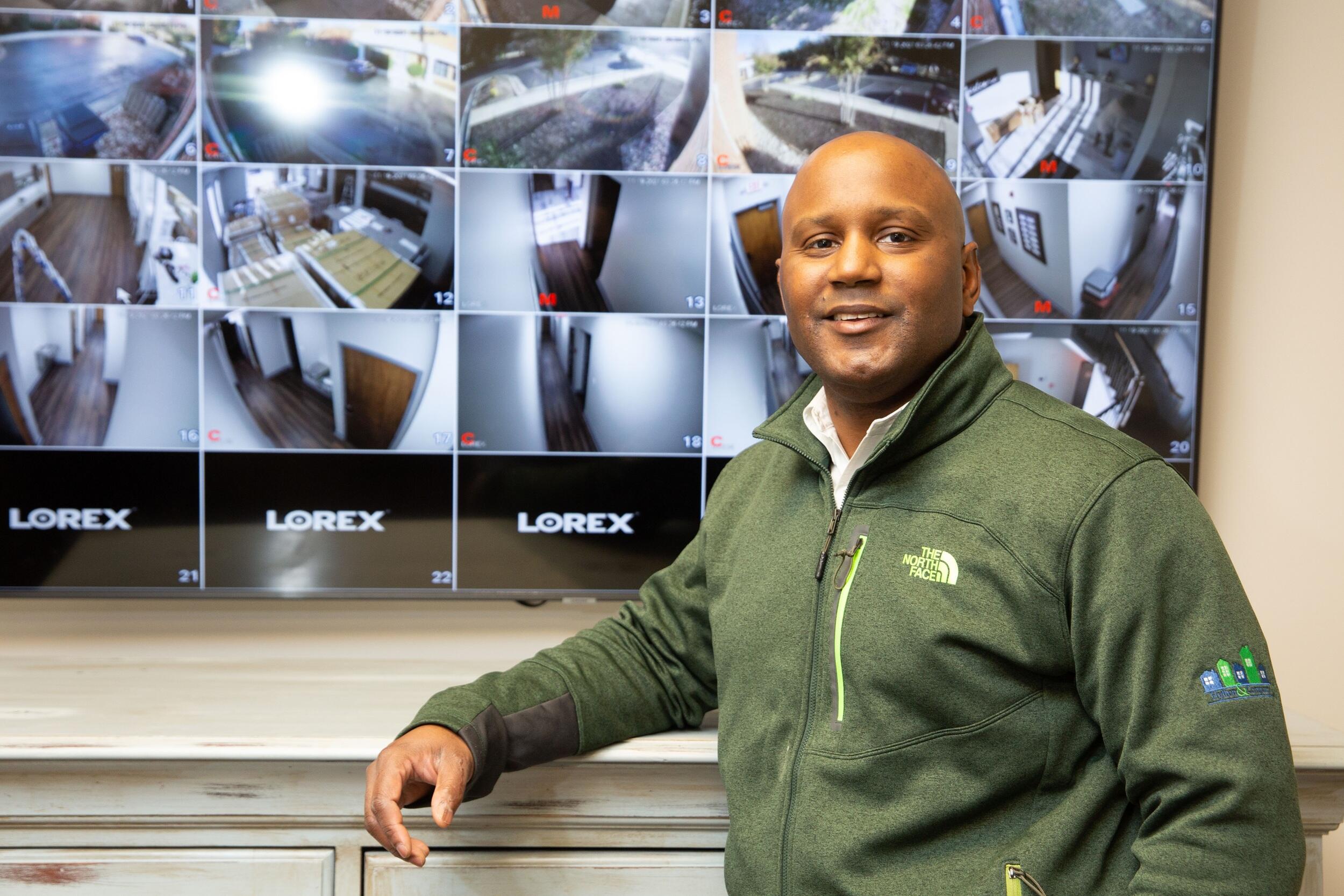 LeQuan Hylton standing in front of a screen showing security camera footage 