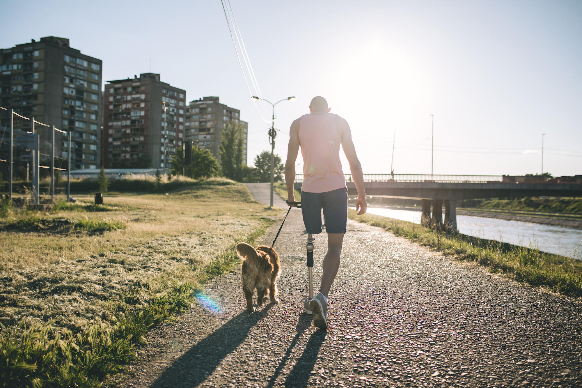 man with prosthetic leg walking his dog