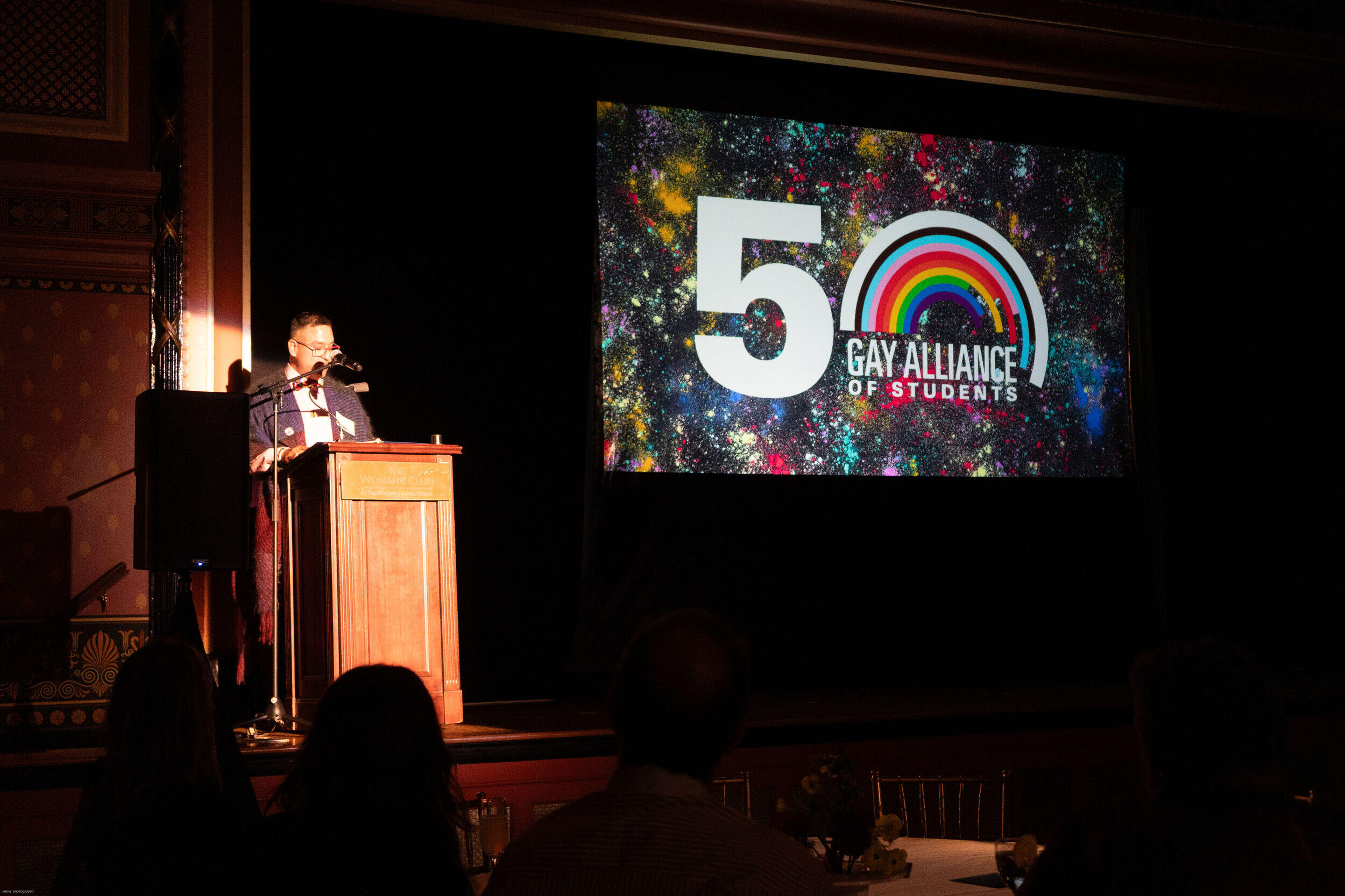 A photo of a man standing behind a podium. 