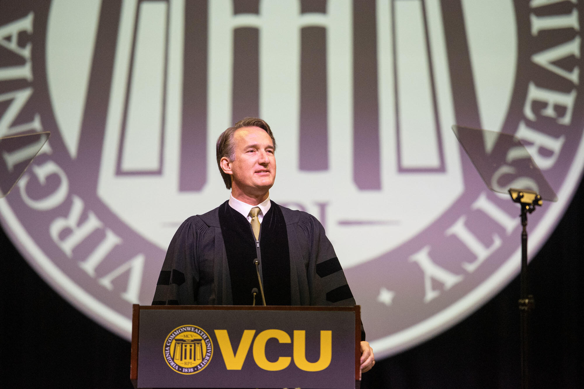 Governor Glenn Youngkin speaking at the podium during VCU's graduation ceremony.