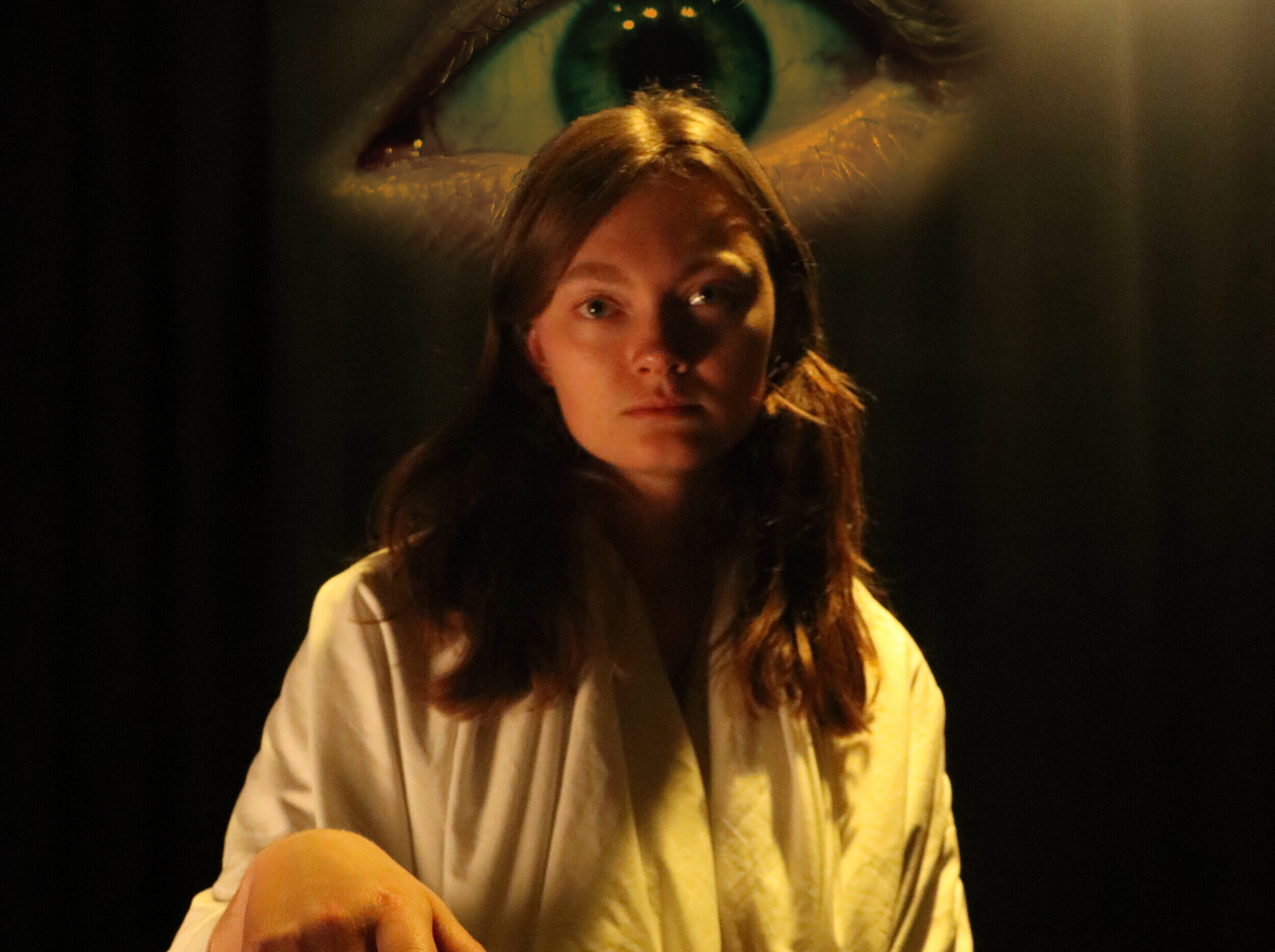 A photo of a woman with a large eye behind her