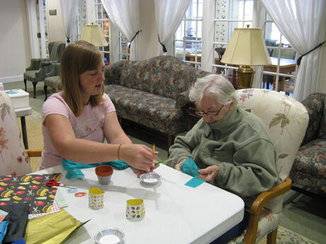Brittany Downer provides instructions for one of her students — a resident of an assisted-living center.