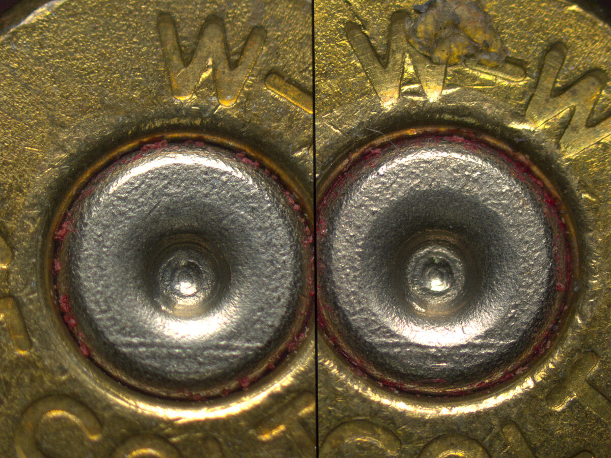 A photo of the base of two bullets up close side by side. 