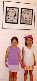 Two Chesterfield students pose beneath their art at the exhibit.

Photo by Jennifer Curtis, University News Services