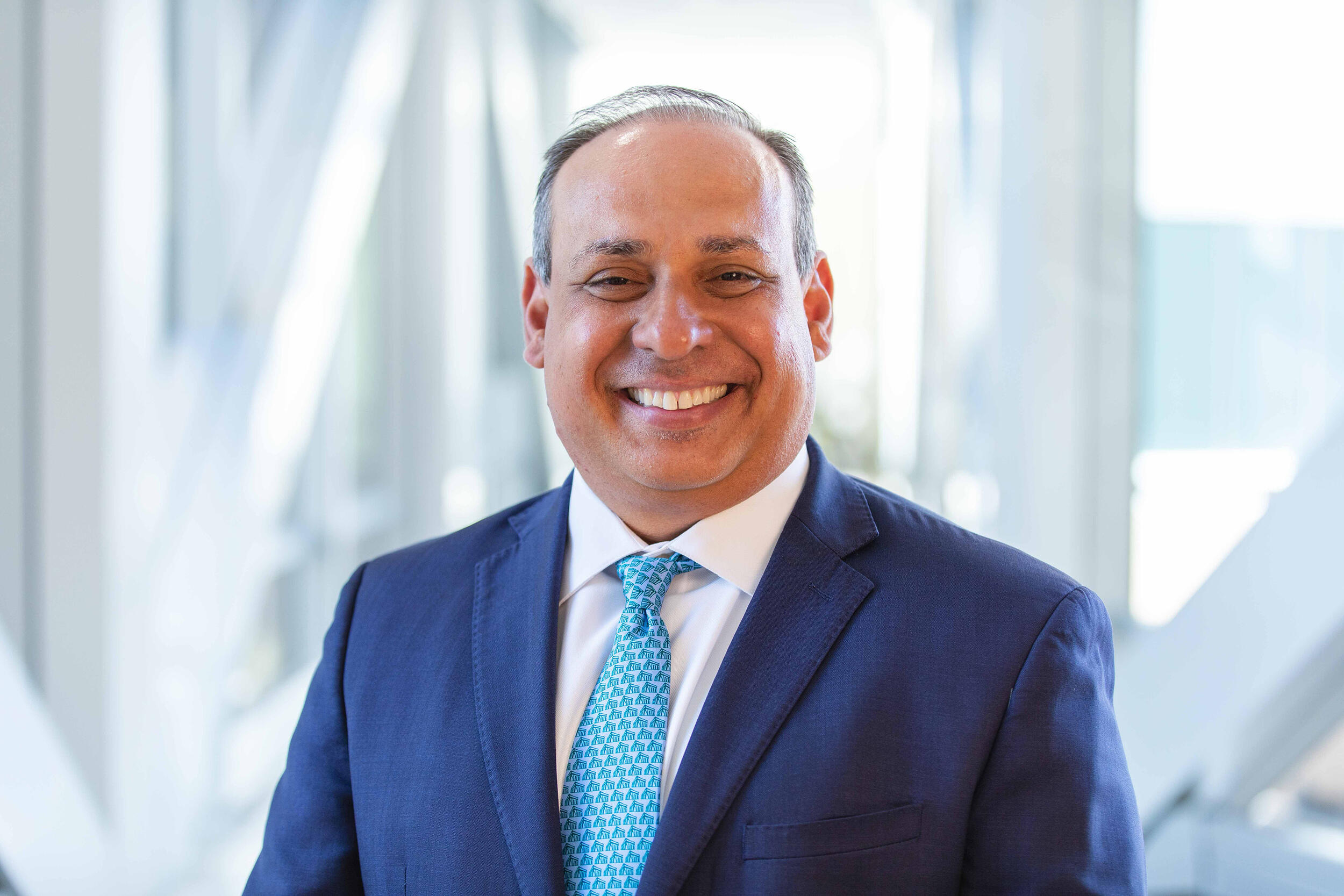 A photo of a man smiling from the chest up. 