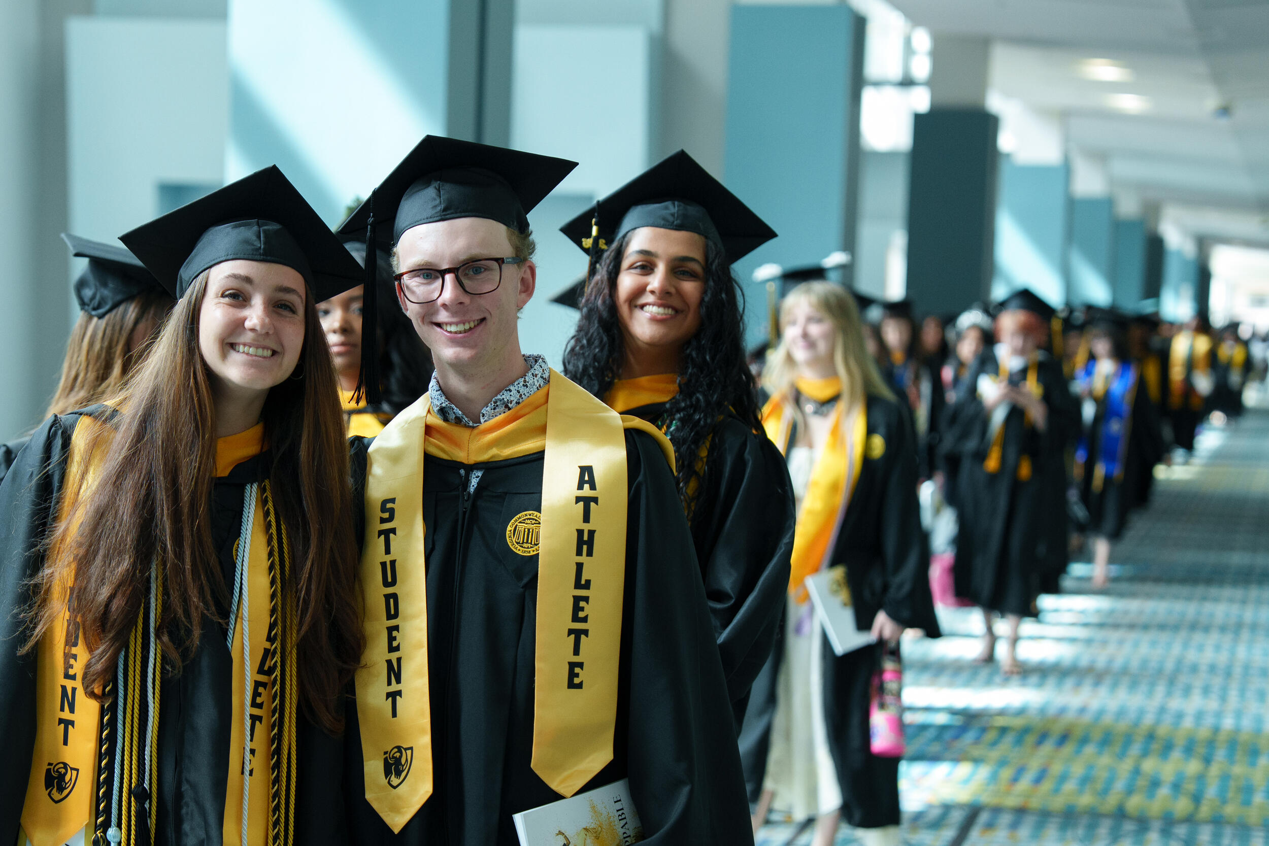 A long row of men and women in caps and gowns.
