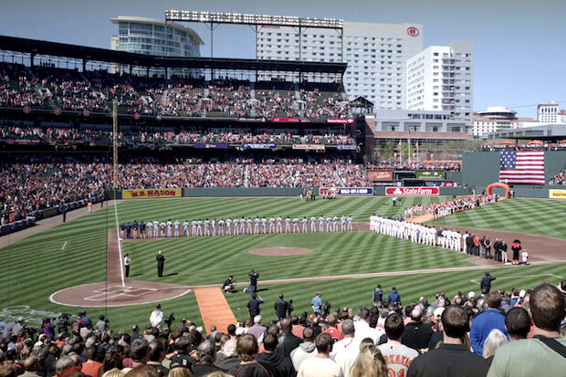Players stand on the field before the playing of the national anthem at Oriole Park at Camden Yards 