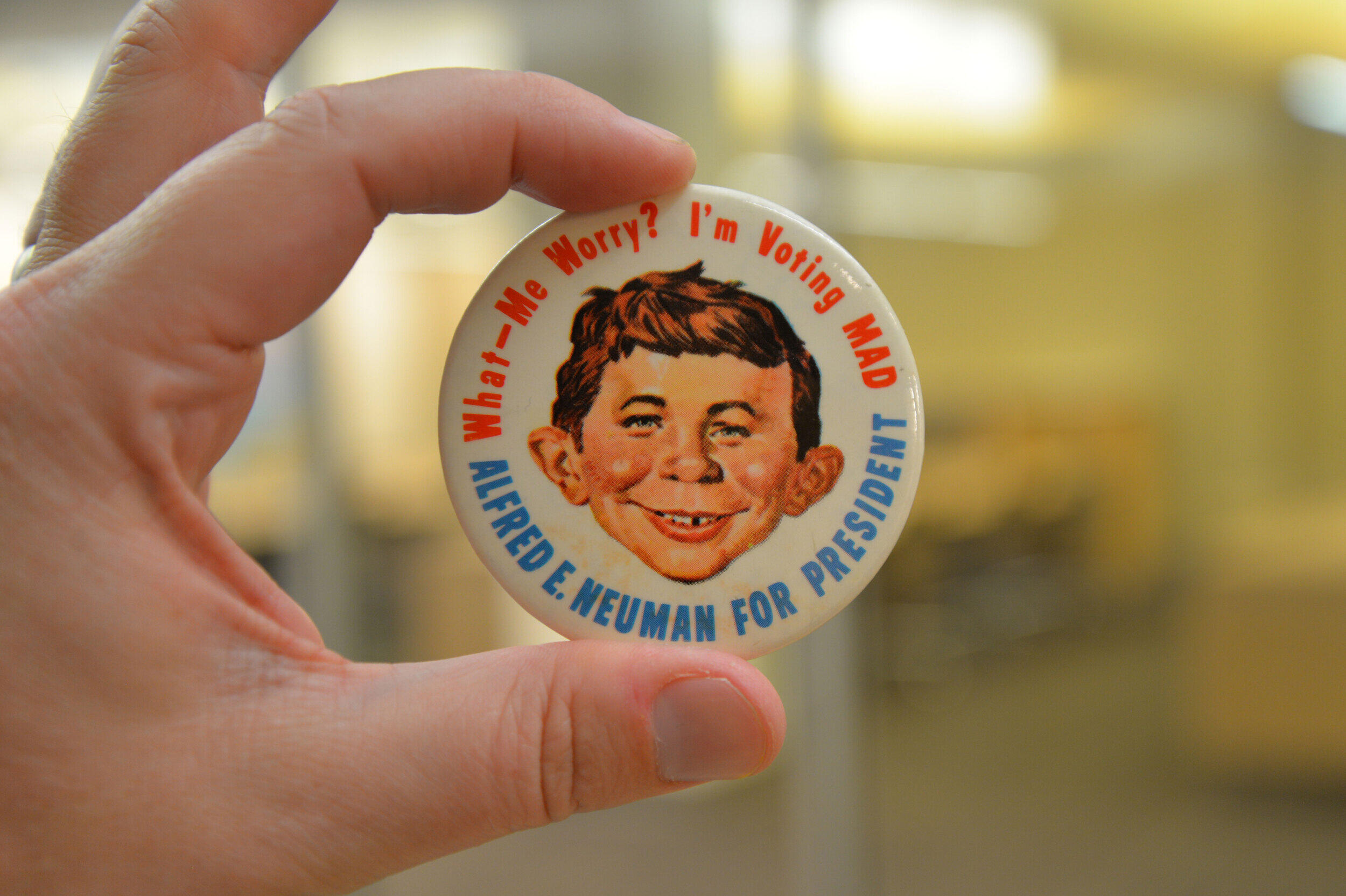 A button with Mad Magazine figure Alfred E. Neuman with \"What-Me Worry? I'm voting MAD\" encircling the top of the button and \"ALFRED E. NEUMAN FOR PRESIDENT\" encircling the bottom.