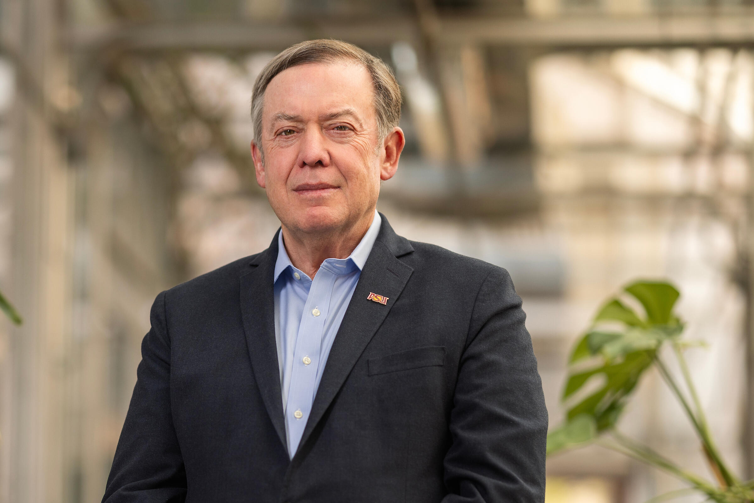 A man in a suit jacket and blue shirt.