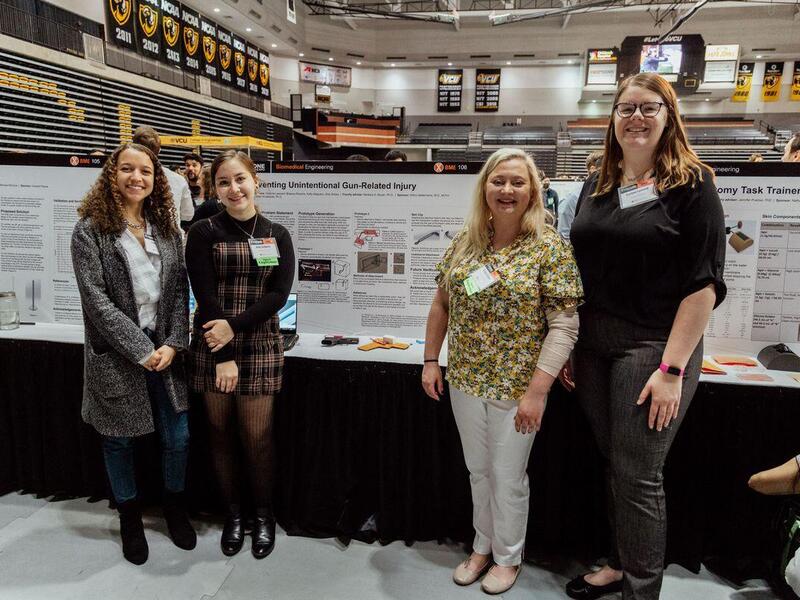 (Left to right) Zoie Sickey, Kelly Salguero, Brianna Roberto and Corinne Leonard standing in front of their presentation. 