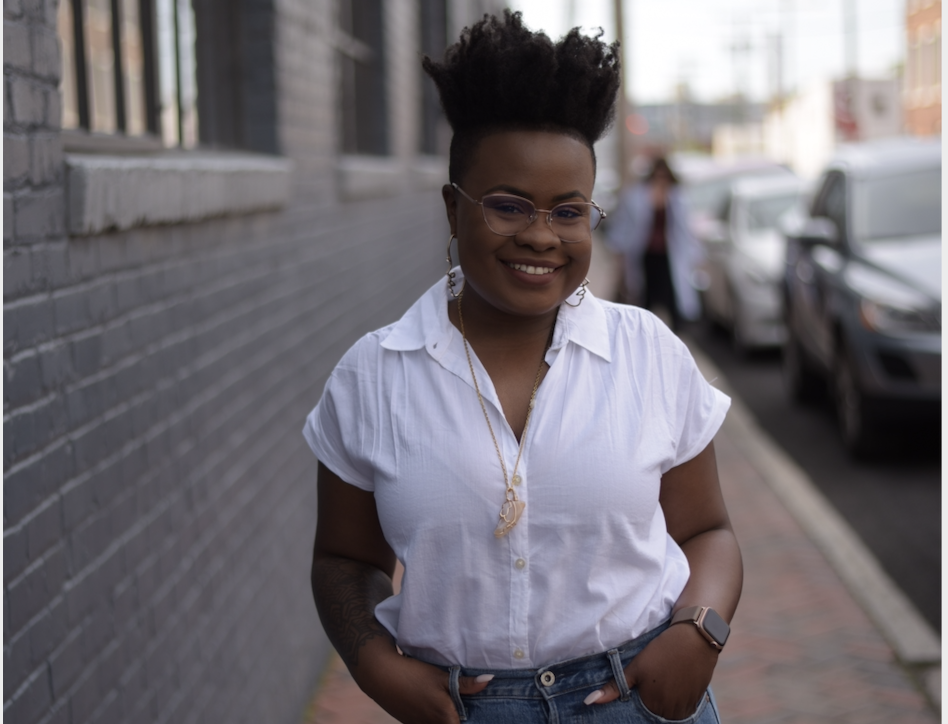Woman smiling on sidewalk. 
