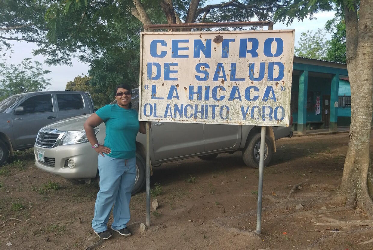 Woman standing next to a sign in Honduras.