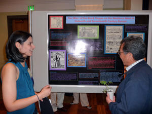 Ranya Abi-Falah explains her research on the Black Plague to a visitor of the poster symposium. Photo by Mike Porter, VCU Communications and Public Relations.