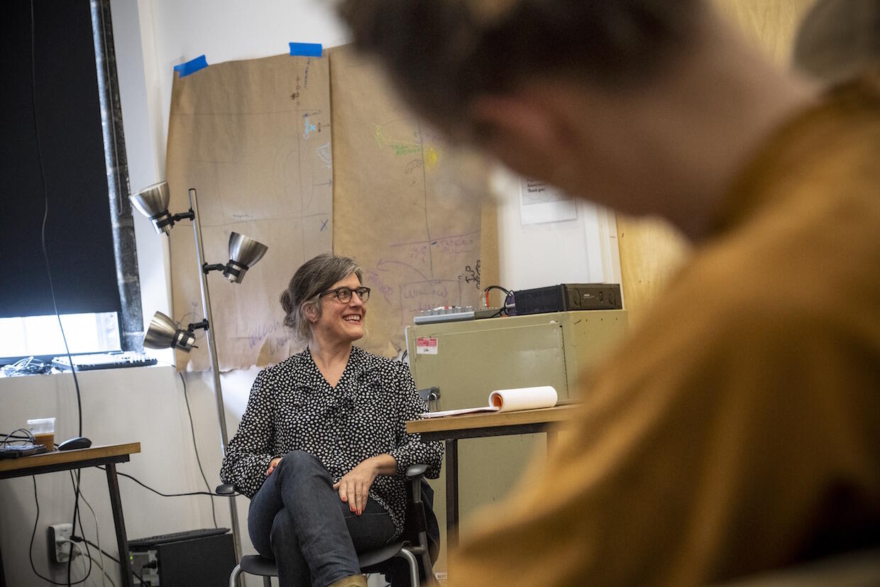 Rebecca Gates sitting in a chair in a VCU classroom, speaking with students.