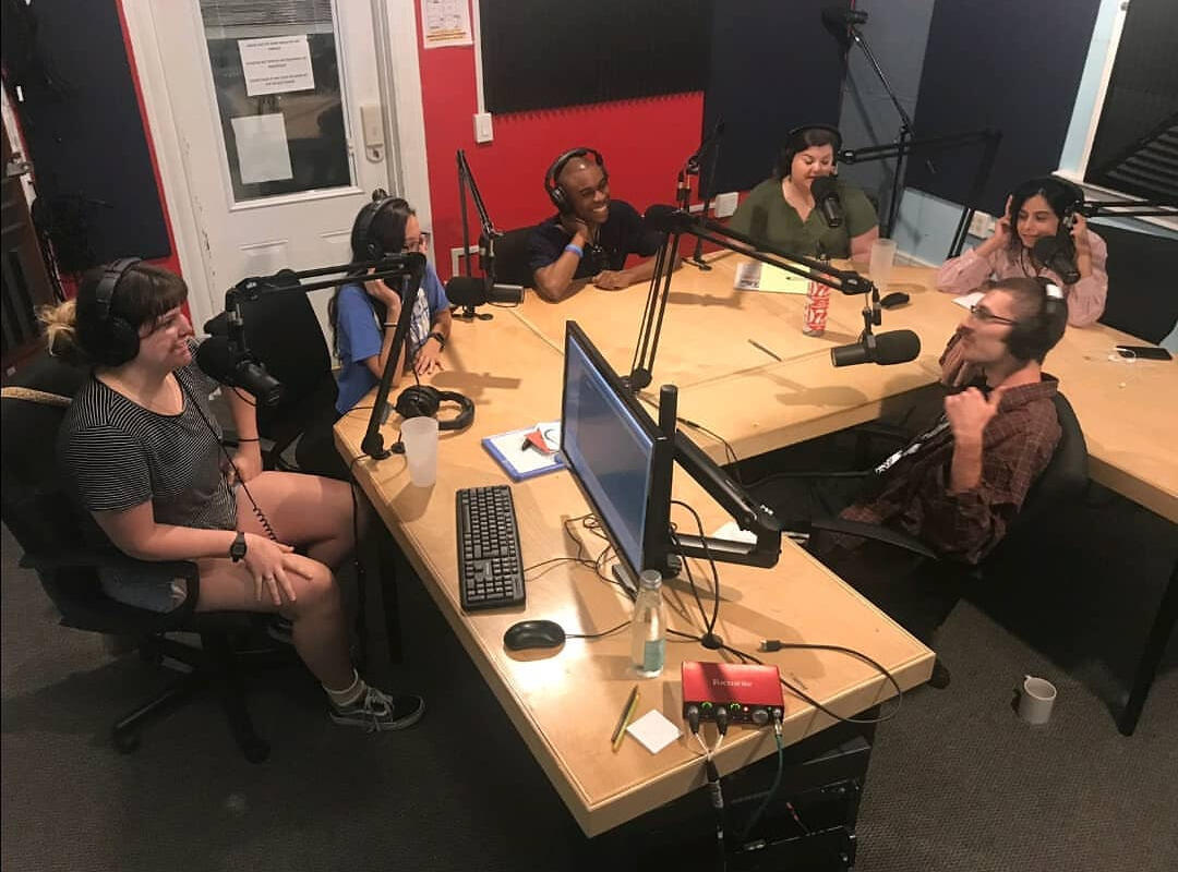 People in recording studio with microphones.