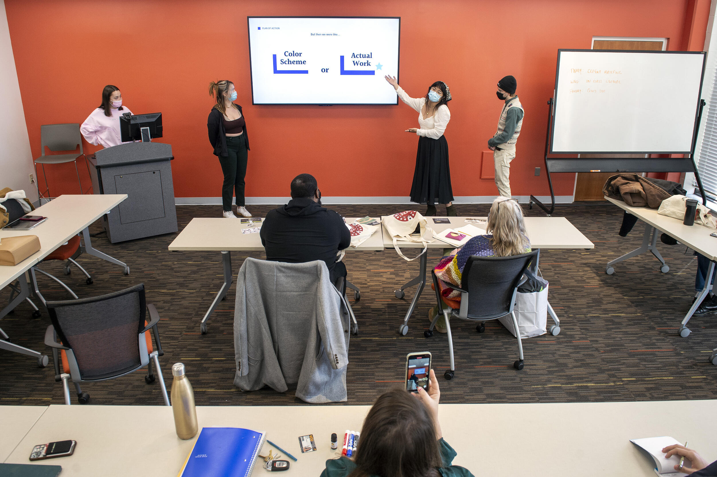 Students giving a presentation at the front of a room