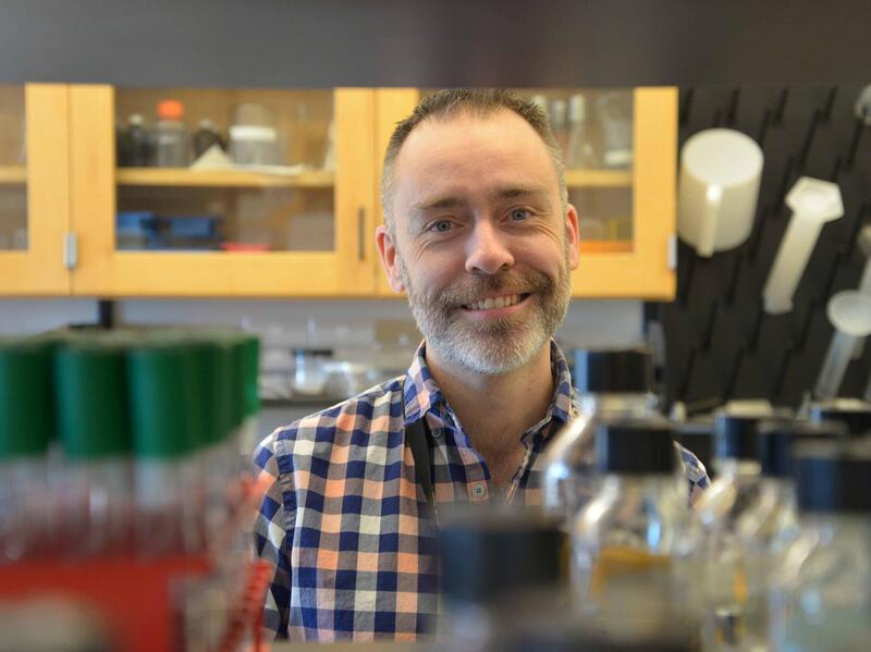 Portrait of Derek Prosser, Ph.D., in a laboratory.