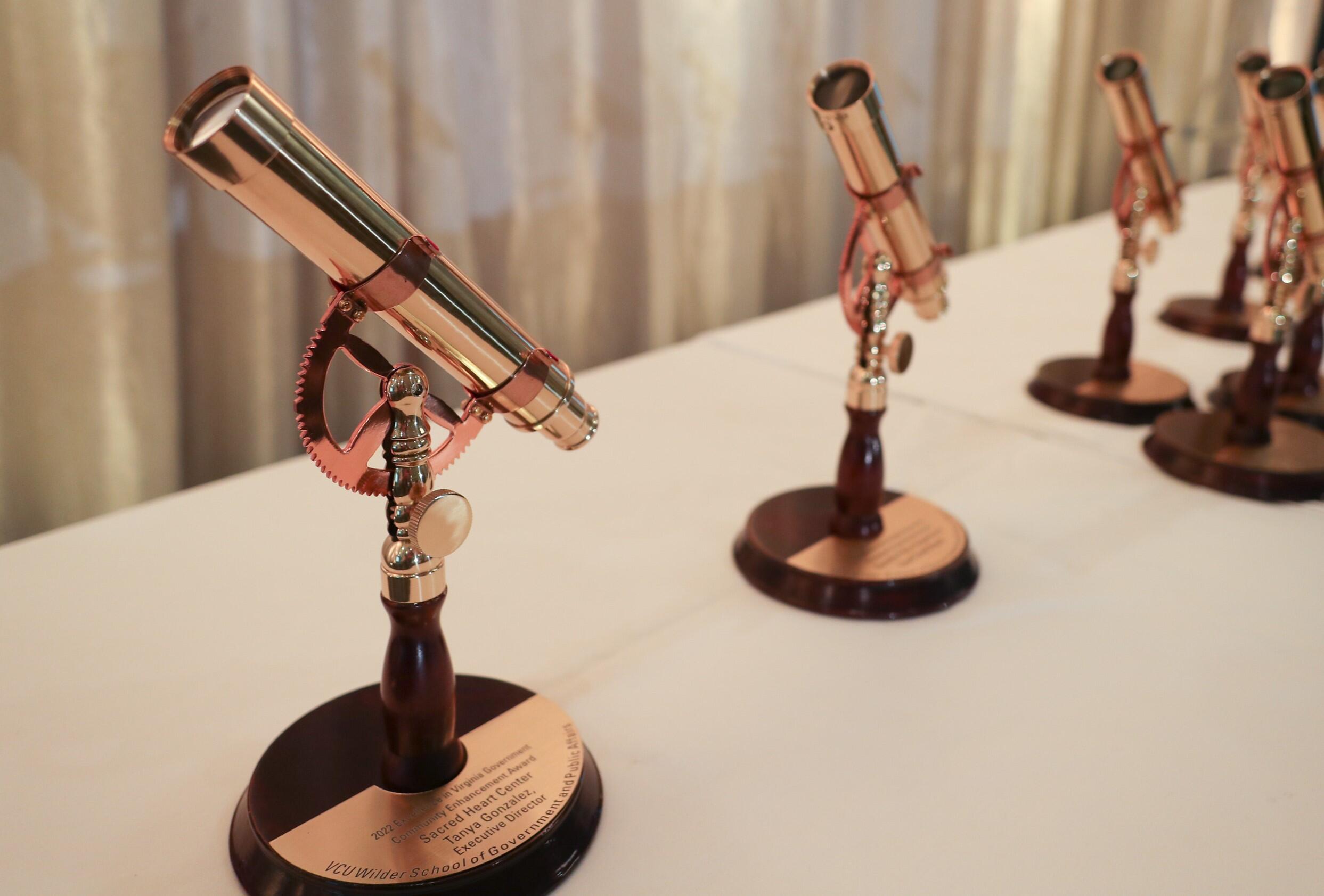 A photo of five awards shaped like telescopes. 