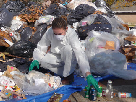 VCU Sustainability Coordinator Jordan Starbuck donned protective gear to sift through trash in a search for items that could have been recycled.  It was part of VCU’s first “Dumpster Dive In” event.  Photo by Mike Porter, VCU Communications and Public Relations. 