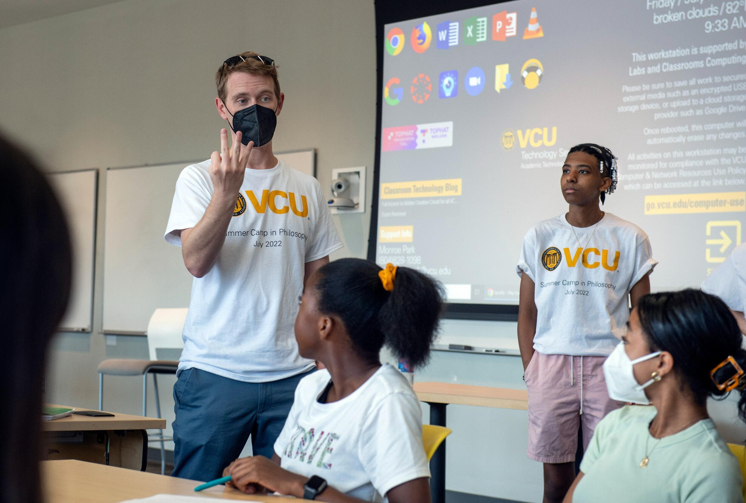 James Fritz, Ph.D., an assistant professor in the Department of Philosophy at VCU's College of Humanities and Sciences and the camp's coordinator, standing, talks with student jurors in a mock trial. versity Marketing)