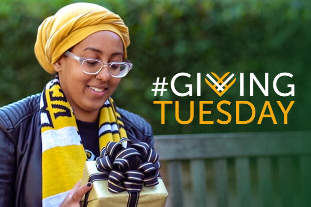 A woman in yellow hat and scarf holds a gift box. Words \"Giving Tuesday\" are at right.