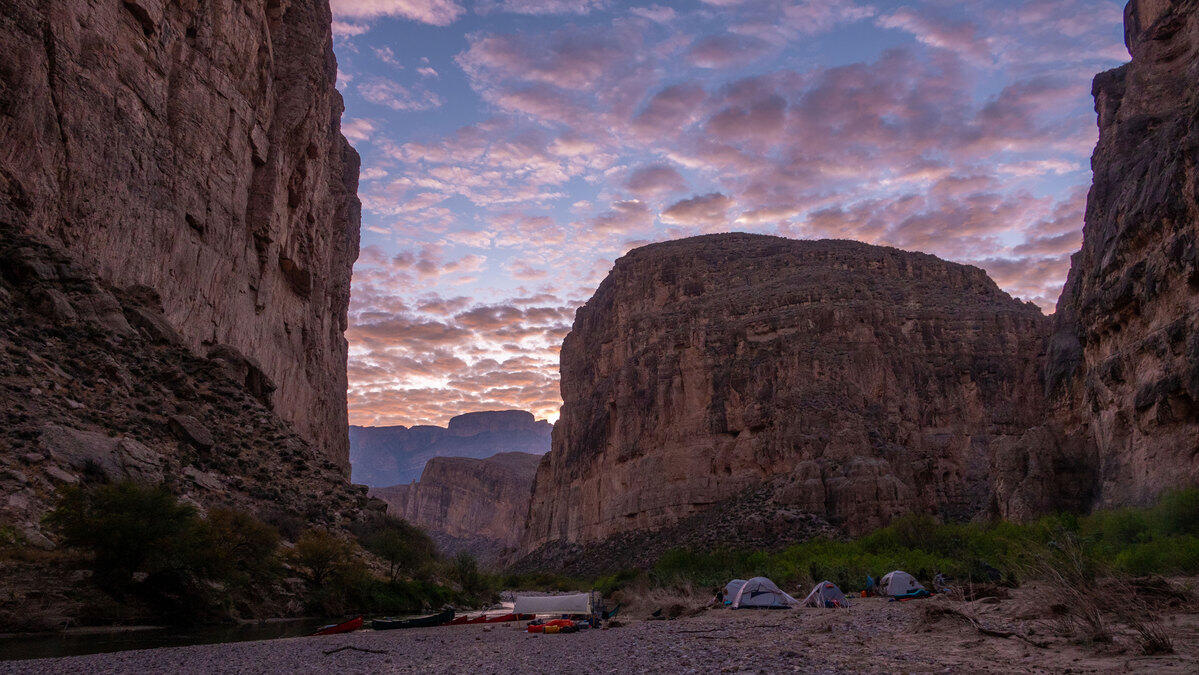 A photo of tents in a canyon. 