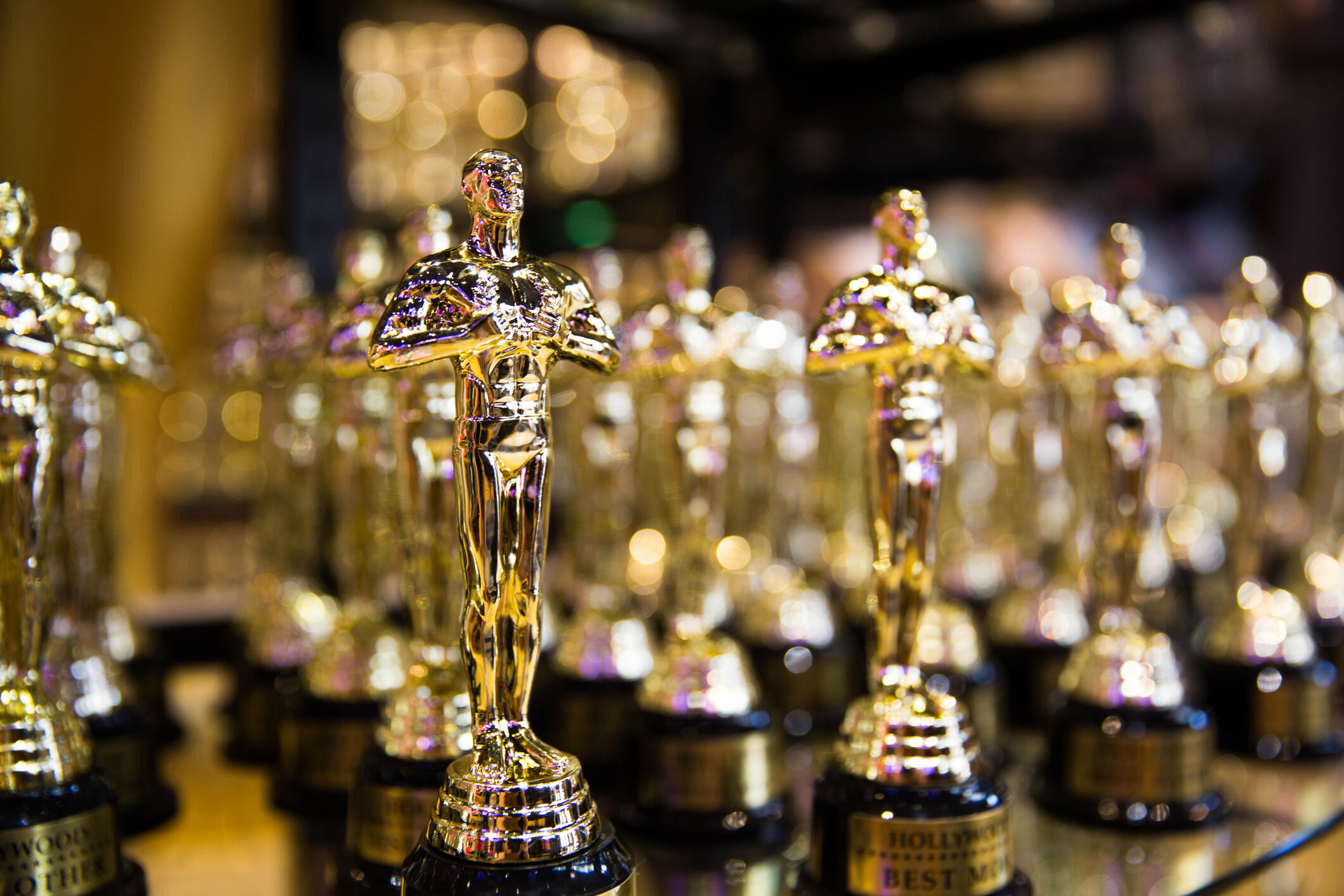 A photo of several Oscar award statues lined up. 