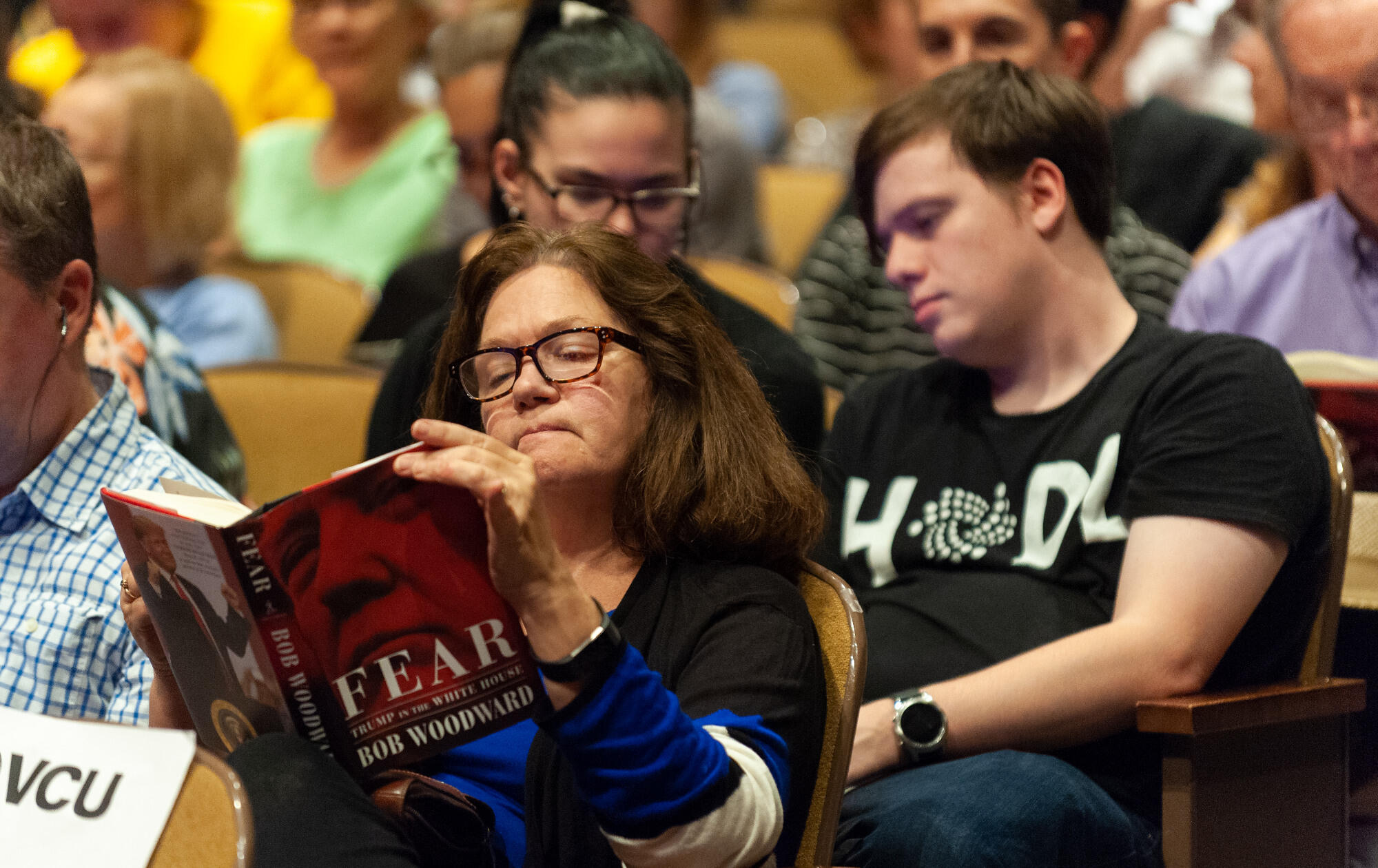 An audience member reads from Bob Woodward's "Fear: Trump in the White House." (Photo by Kevin Morley, University Relations)