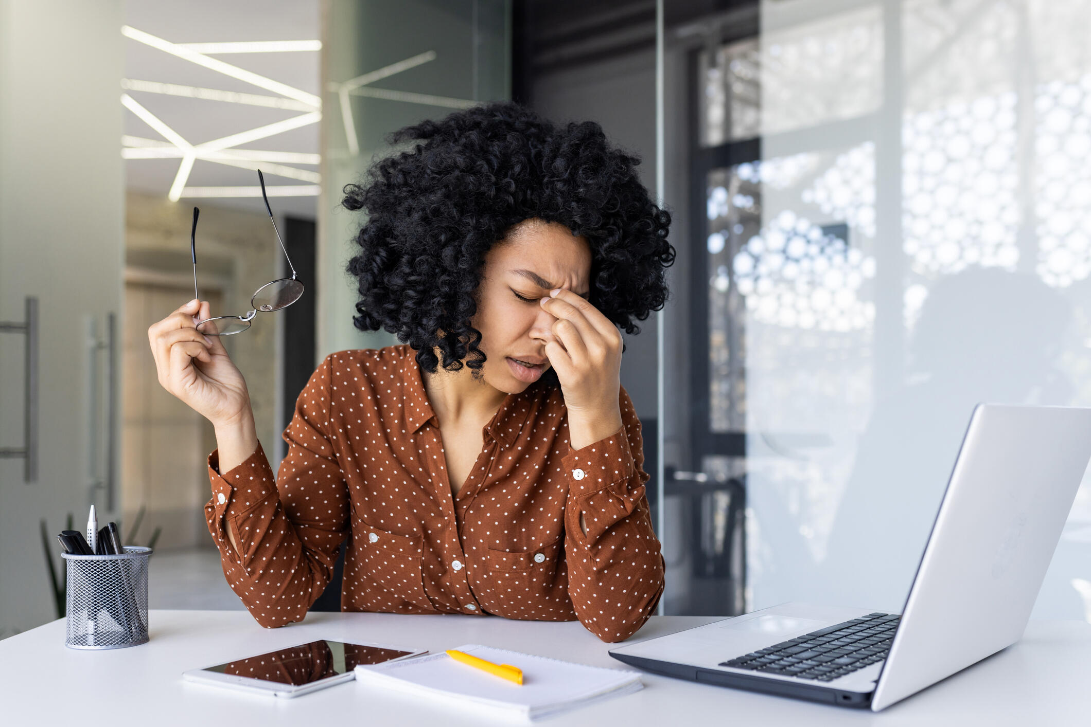 A photo of a woman sitting at a desk with a laptop on it