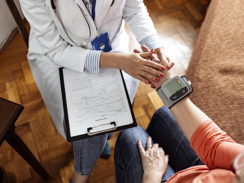 A doctor holding a patient's hand for an examination 