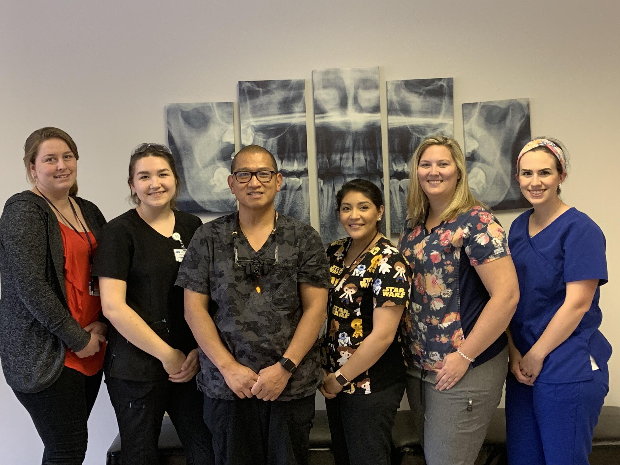Sonny Duong stands with five of his dental practice colleagues.