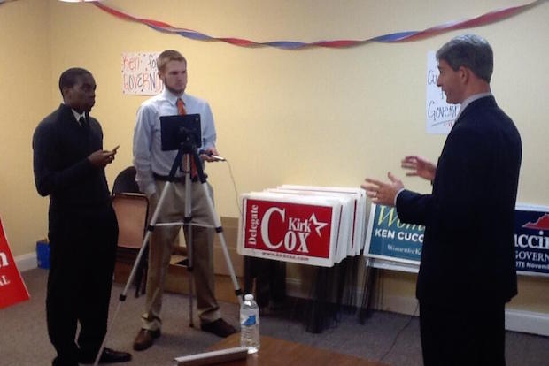 Student with microphone and cameraman interview man running for governor. 