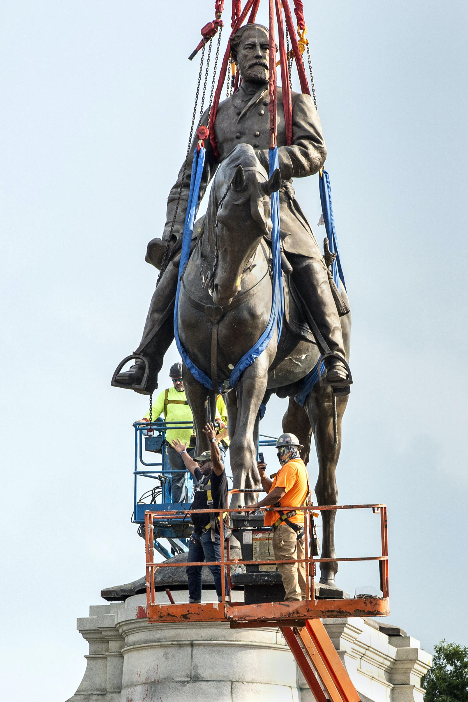 Workers prepare to remove the Robert E. Lee statue from its plinth