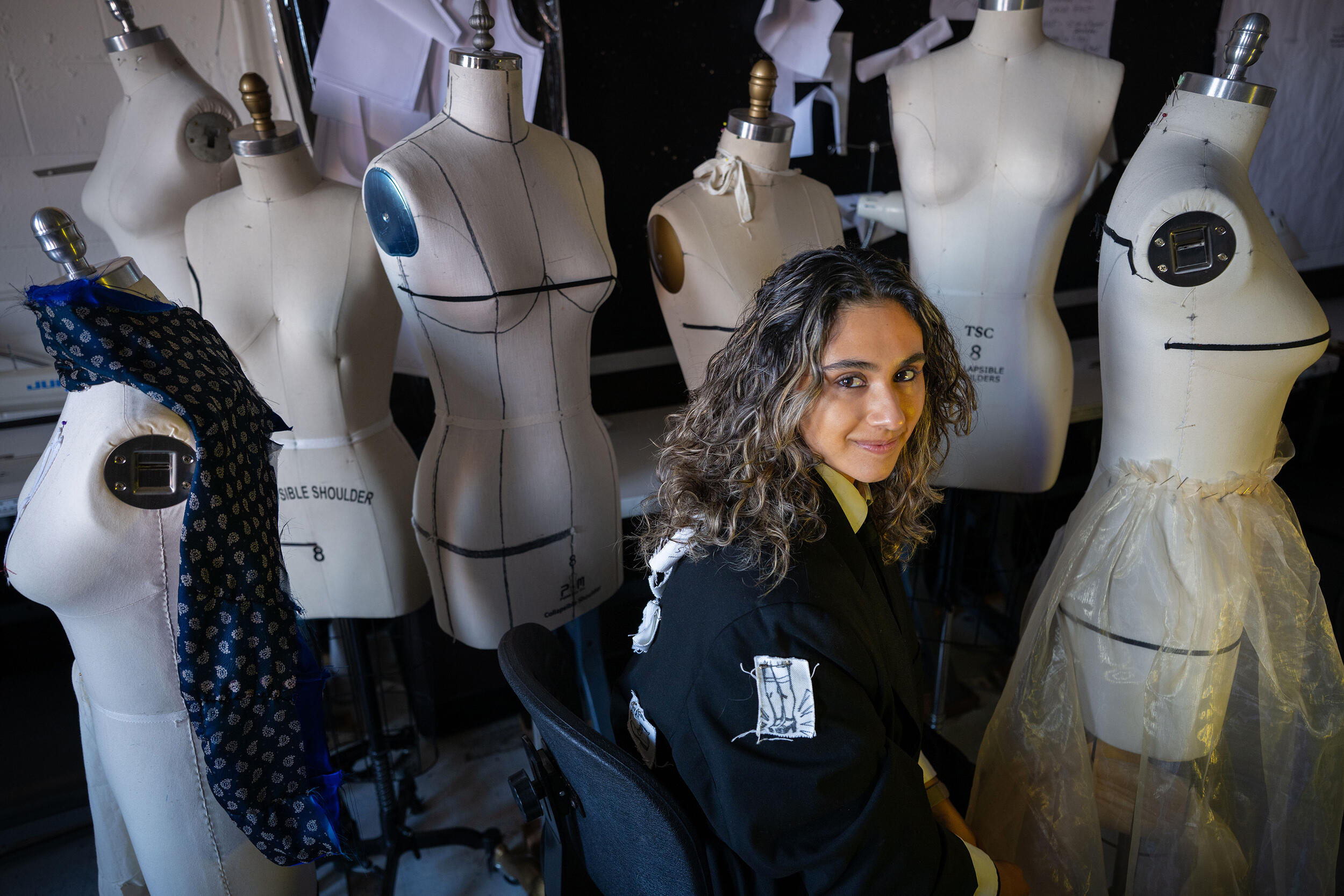 A photo of a woman sewing at a table. 
