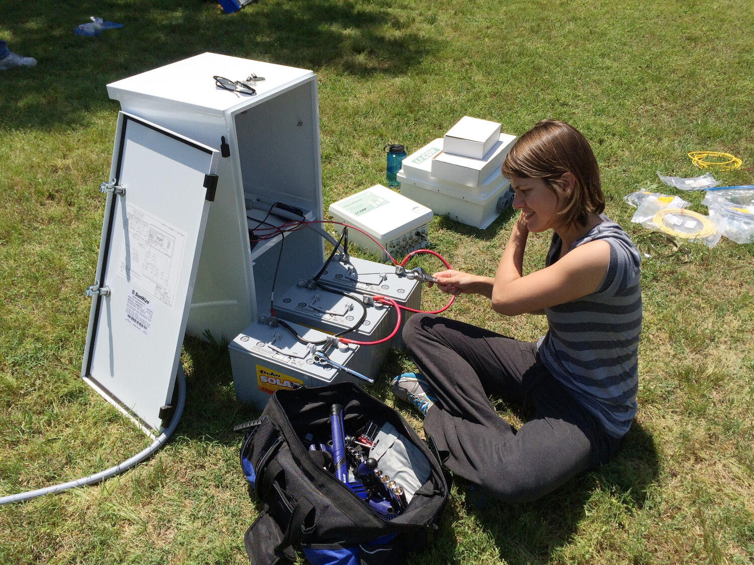  Ellen Stuart-Haentjens, a Ph.D. student, sets up the batteries for the solar panel that powers the flux tower instruments.