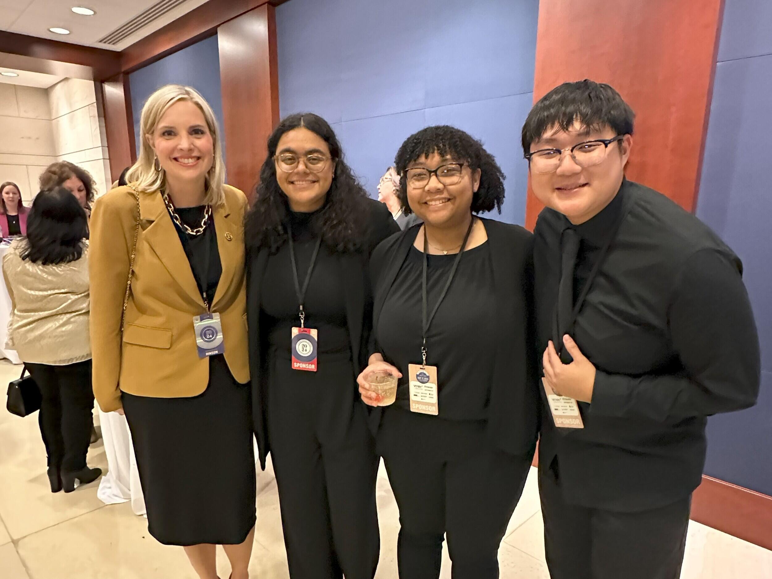 A group photo of four people standing. 