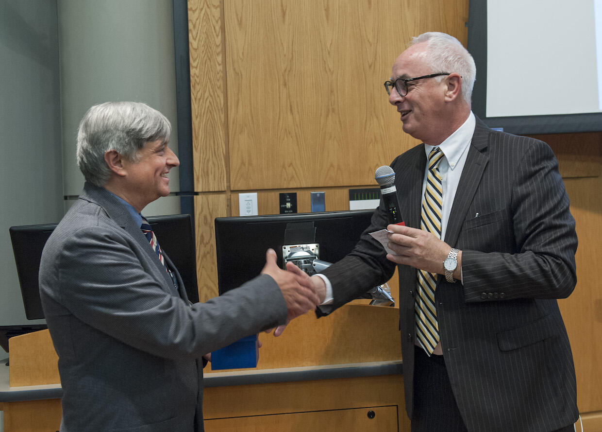 Peter Buckley, dean of the VCU School of Medicine, shakes hands with Taubenberger at Monday's event. (Photo by Kevin Morley University Marketing)