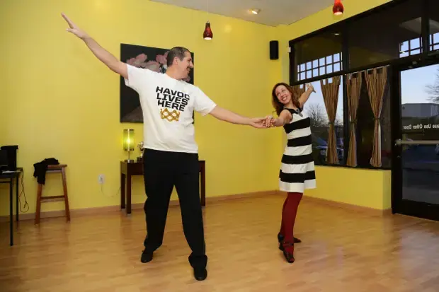 A photo of a man and woman dancing in an open room. 